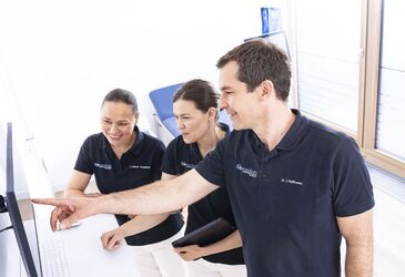 Dr. med. Jonas Hoffmann, Dr. med. Manuela Micheel und Amei Röhner-Zangiabadi schauen gemeinsam auf eine Ultraschalluntersuchung